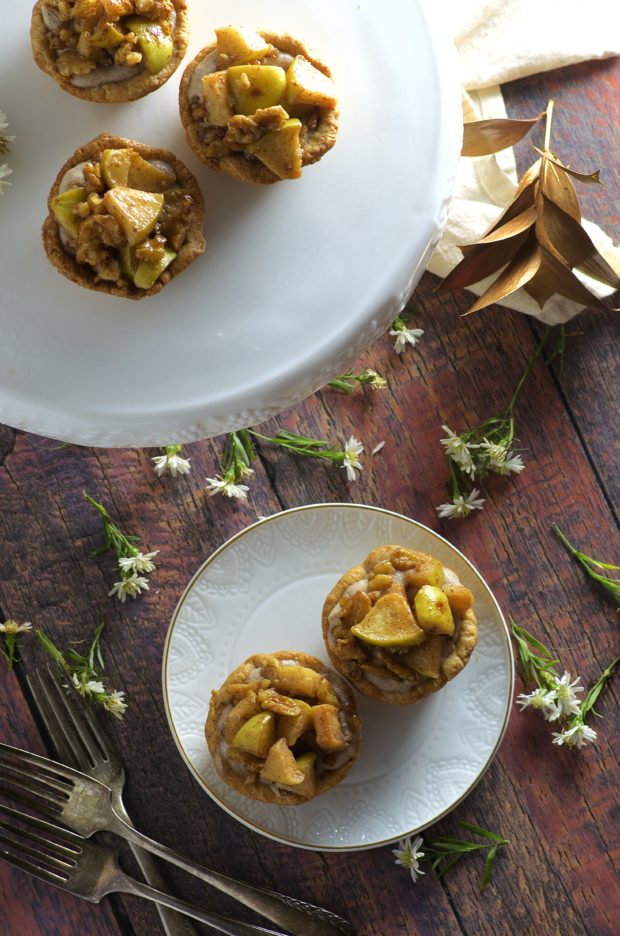Bite Size Apple Pies, filled with sweet, rich cream cheese with a touch of cinnamon and maple syrup, topped with tart organic apples. The perfect little treat to welcome fall.