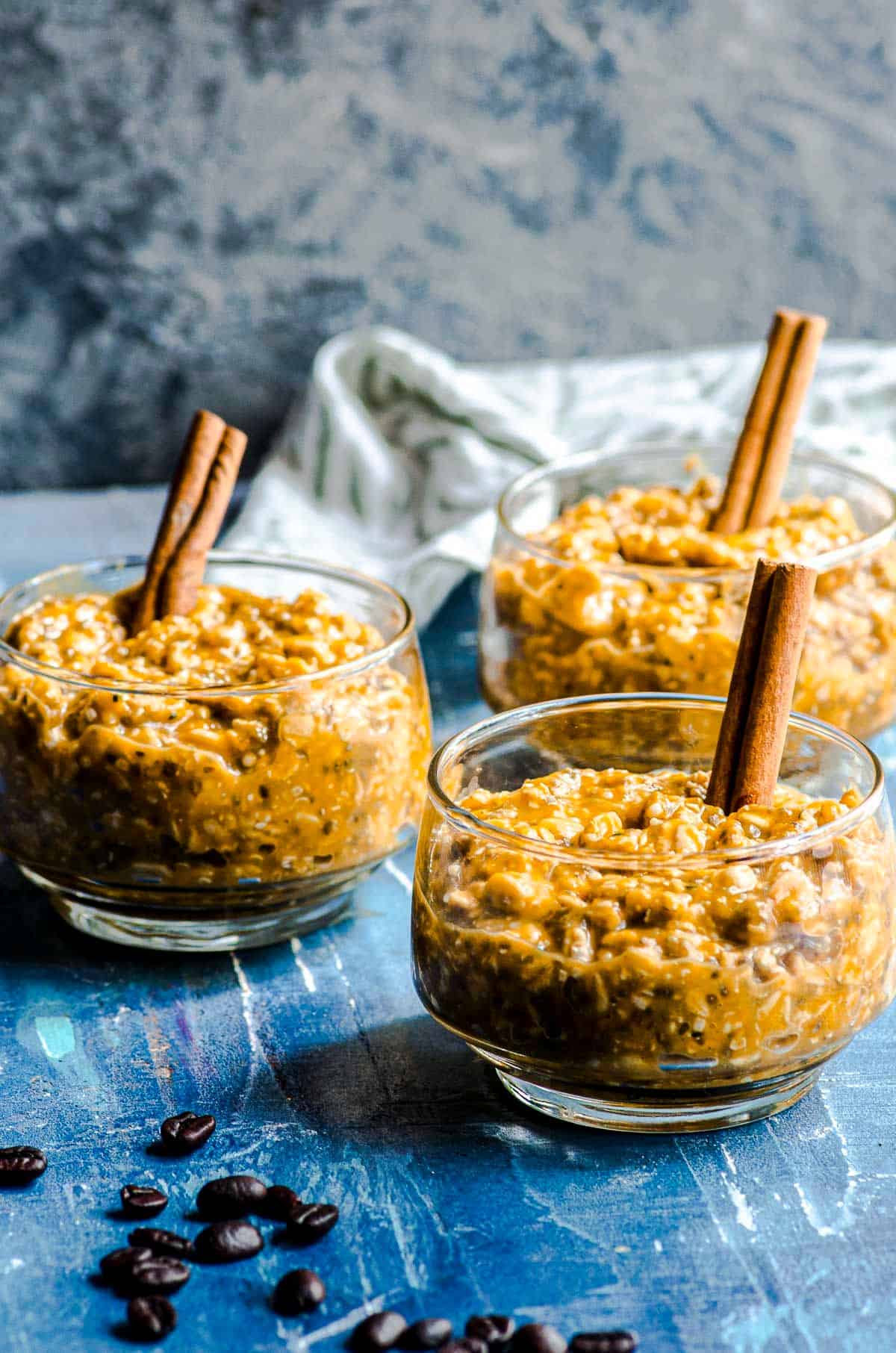 Three clear glass bowls filled with pumpkin overnight oats