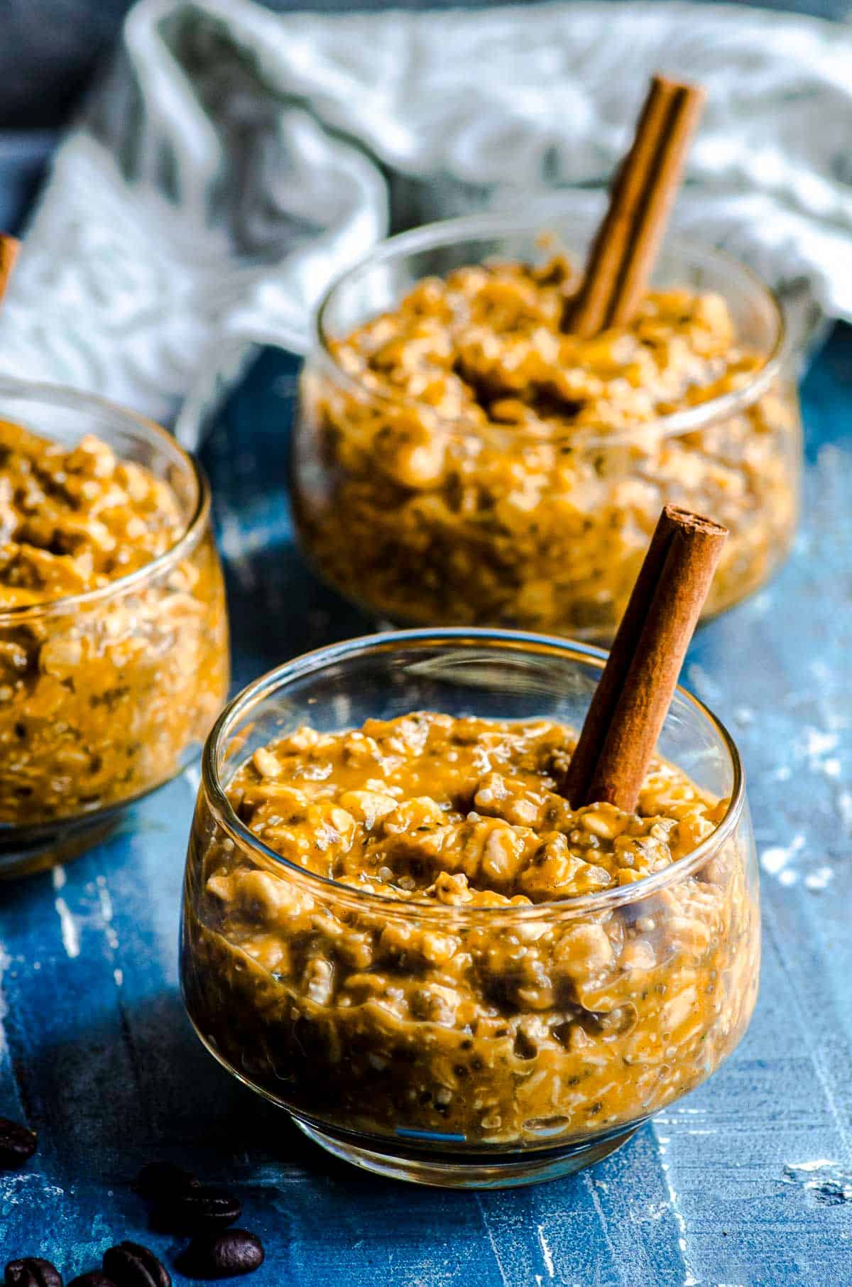 Three clear glass bowls filled with pumpkin overnight oats