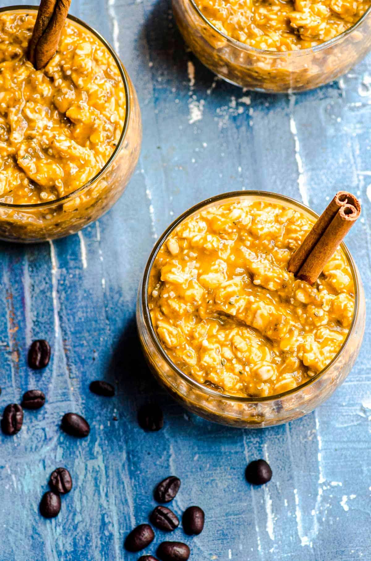 An overhead view of three clear bowls of pumpkin spice overnight oats