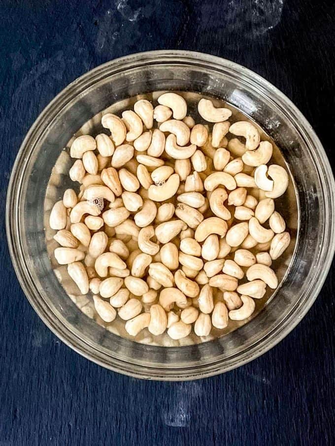 an overhead view of cashews being soaked in boiling water