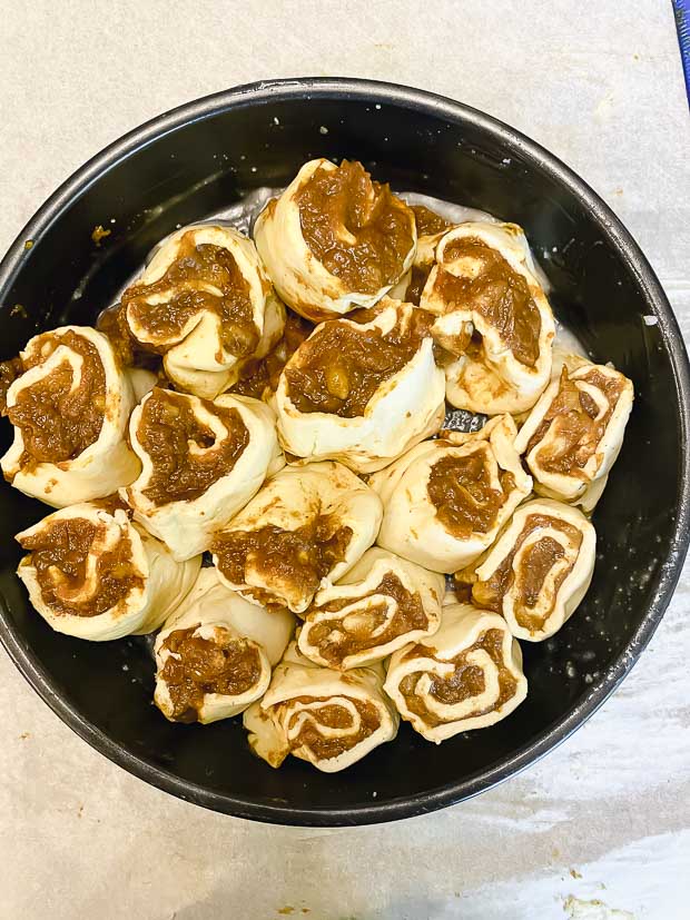 Cut unbaked cinnamon buns in a round baking pan