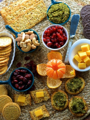 Overhead view of a cheese, nuts, nut dip appetizer board
