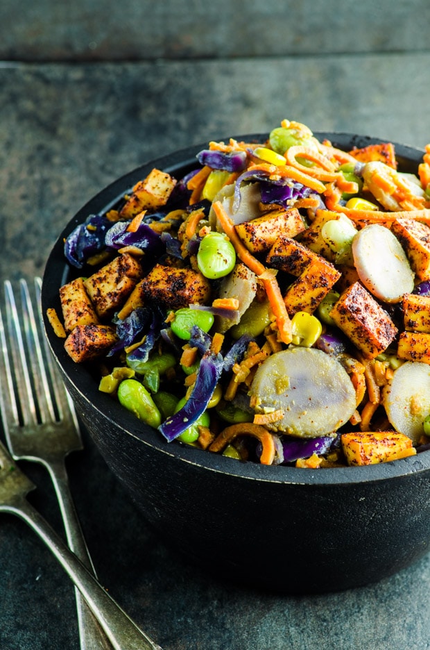 Spiralized sweet potato noodles, purple cabbage, edamame, corn, water chestnuts and tofu in a creamy peanut sauce transform this dinner bowl into a healthy vegan and vegetarian dinner.