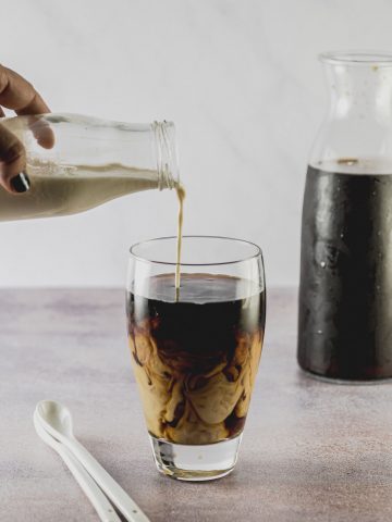 pouring milk on cold brew coffee