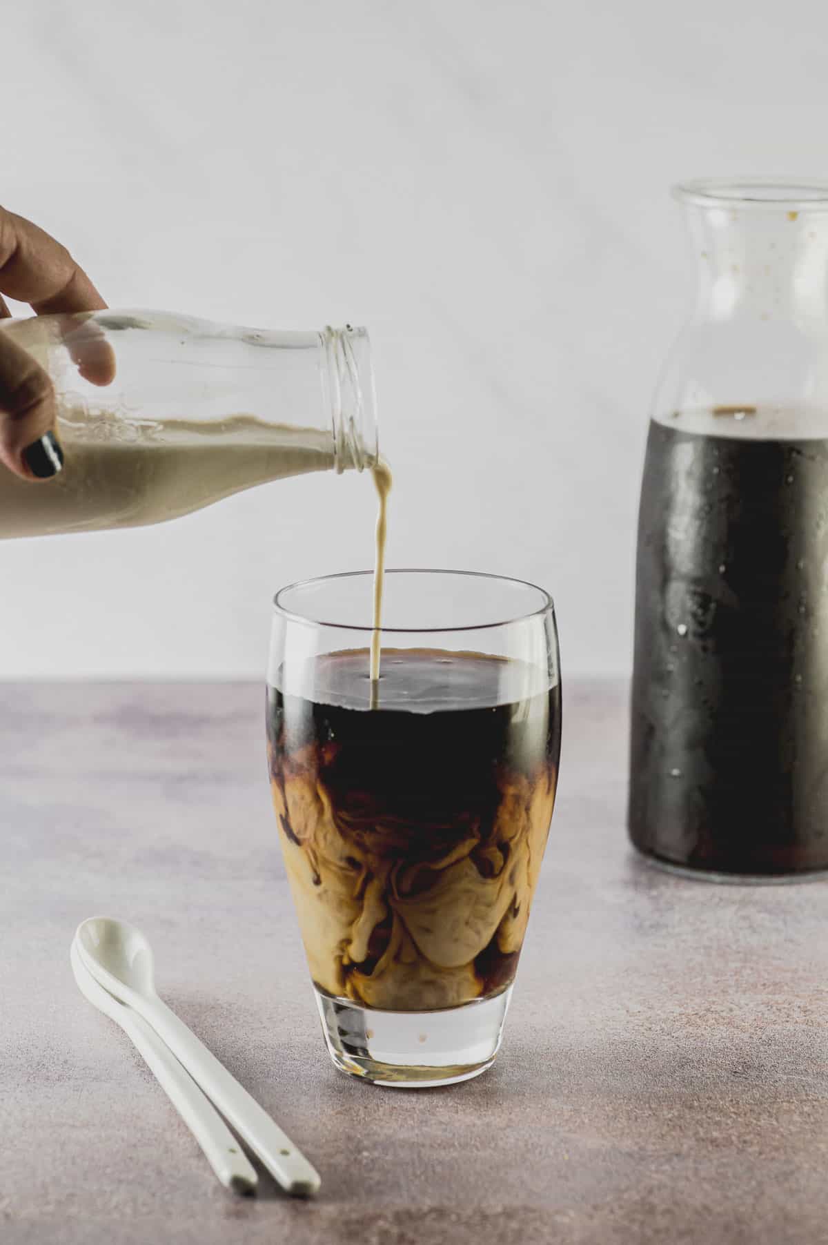 pouring milk on cold brew coffee