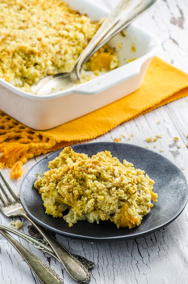 A scoop of cauliflower gratin and in the background a full baking dish.