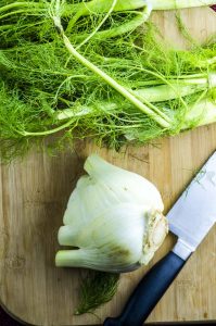 cutting fronds off a fennel for fennel salad