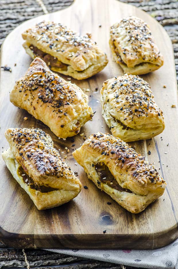 Six Pumpkin Apple Bourekas with Everything Bagel Seasoning, placed on a rectangular wooden cutting board with a handle