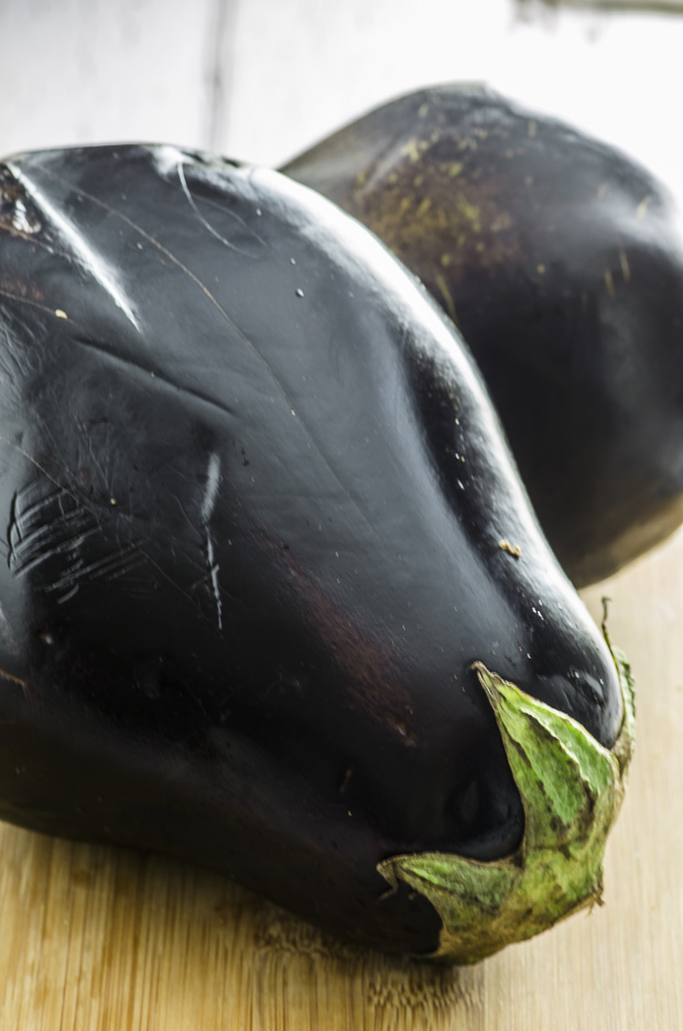 Close up of a fresh eggplant on a wooden cutting board