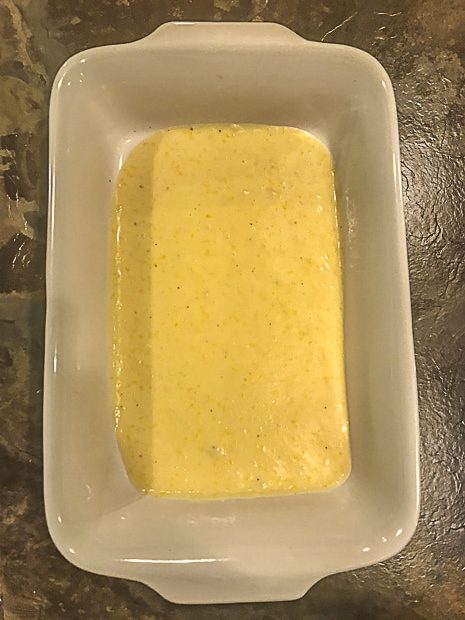 A baking dish with bechamel sauce spread at the bottom of the dish