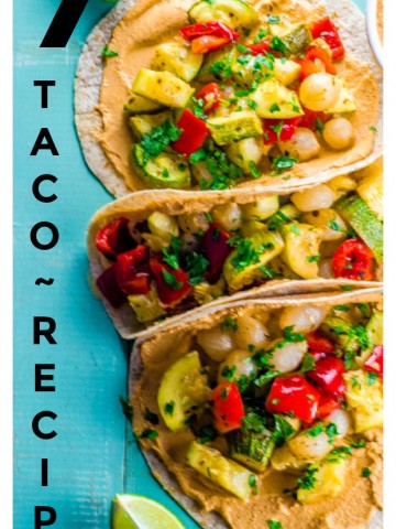 three roasted vegetable and chipotle hummus vegan tacos on a teal colores wooden surface. There are 4 lime slices 2 on top of the images and 2 at the bottom. The is vertical lettering that reads 7 taco recipes,