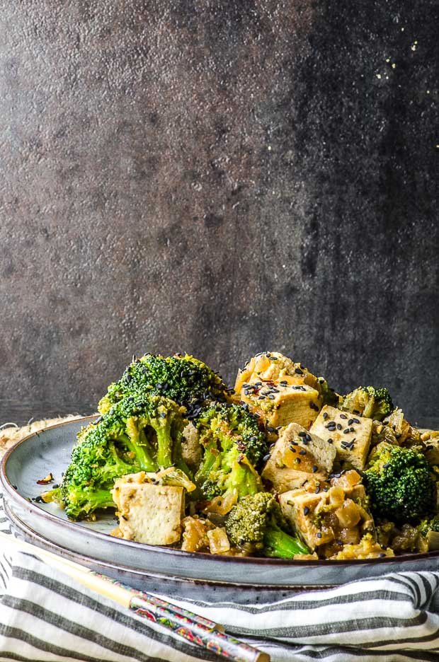 Close up of the Sesame Teriyaki Tofu and Roasted Broccoli Sheet Pan Dinner, on a white a gray stiped cloth napkin