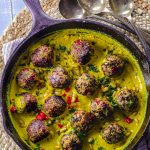 bird's-eye view of a cast iron skillet with Quinoa lentil meatballs with tahini turmeric sauce