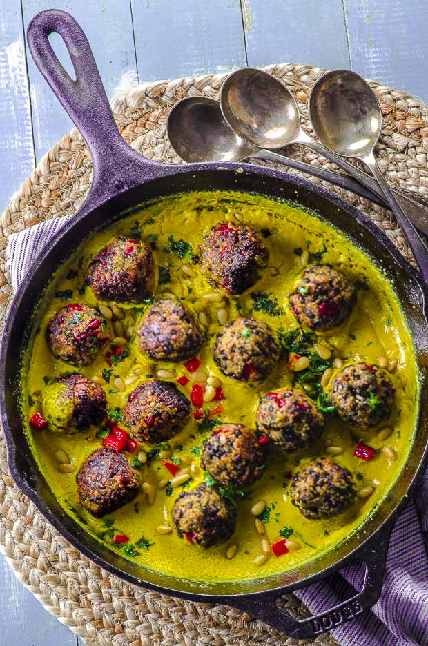 bird's-eye view of a cast iron skillet with Quinoa lentil meatballs with tahini turmeric sauce