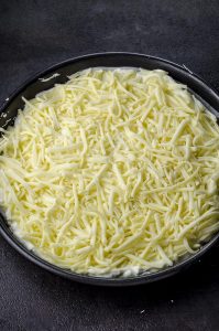 Cheese on top of ricotta on top of kataifi in a round pan
