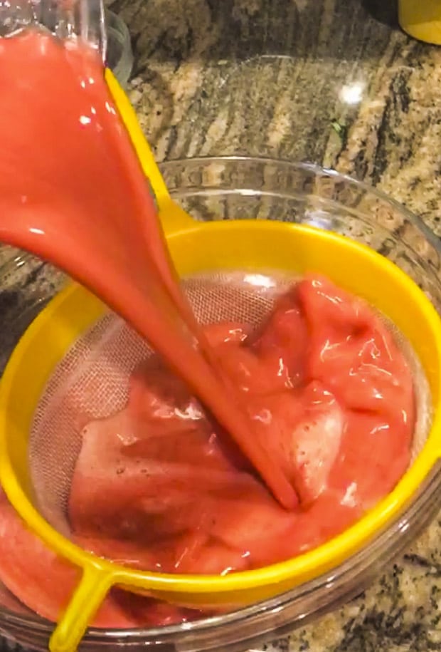 Straining the seeds of a raspberry lemonade