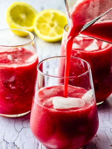 Pouring raspberry lemonade into a glass