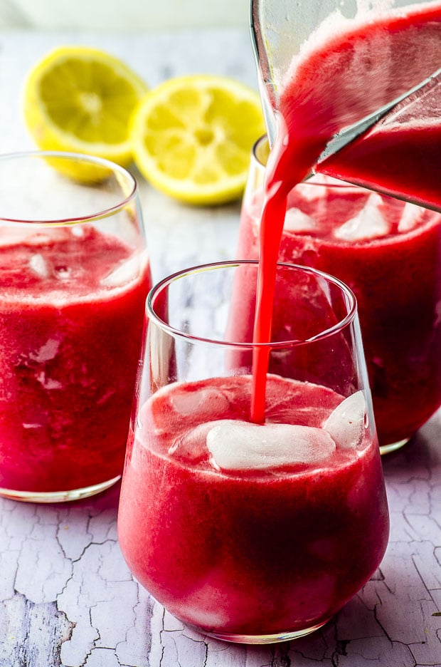 Pouring raspberry lemonade into a glass 