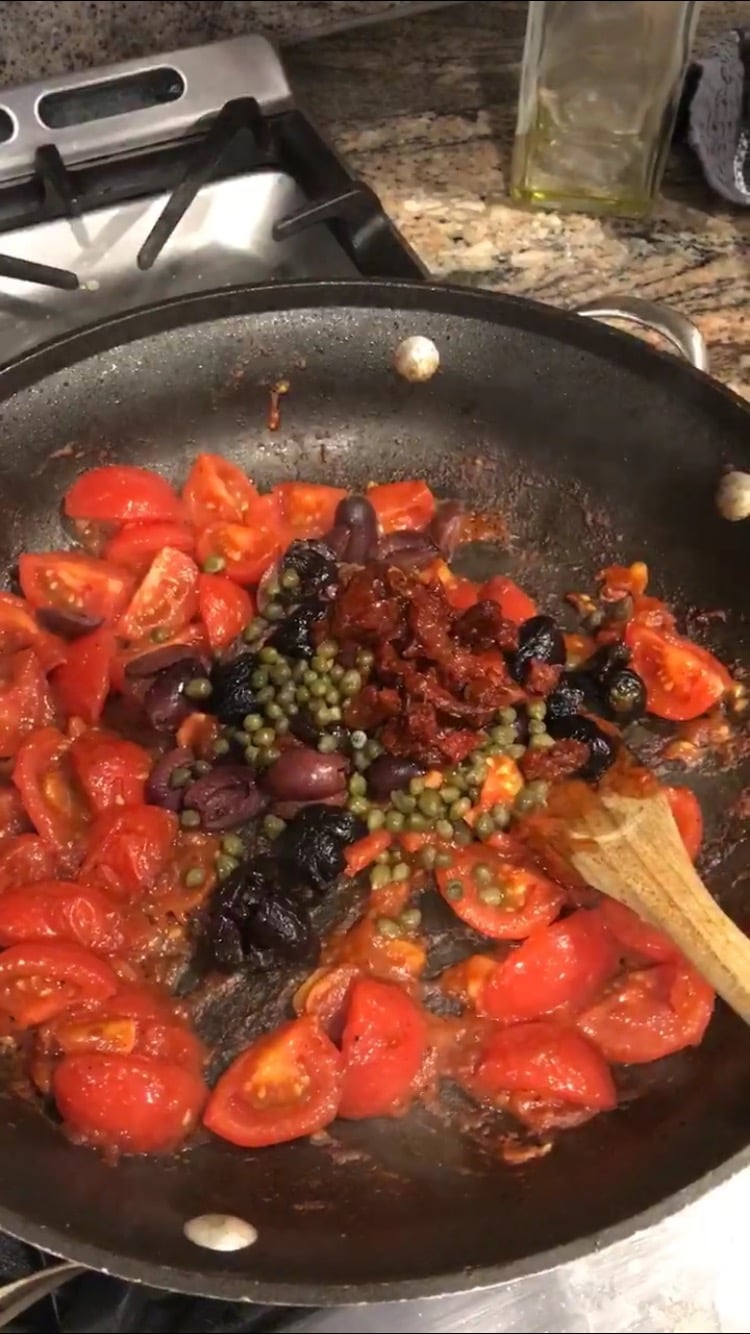 preparing pasta puttanesca in a pan