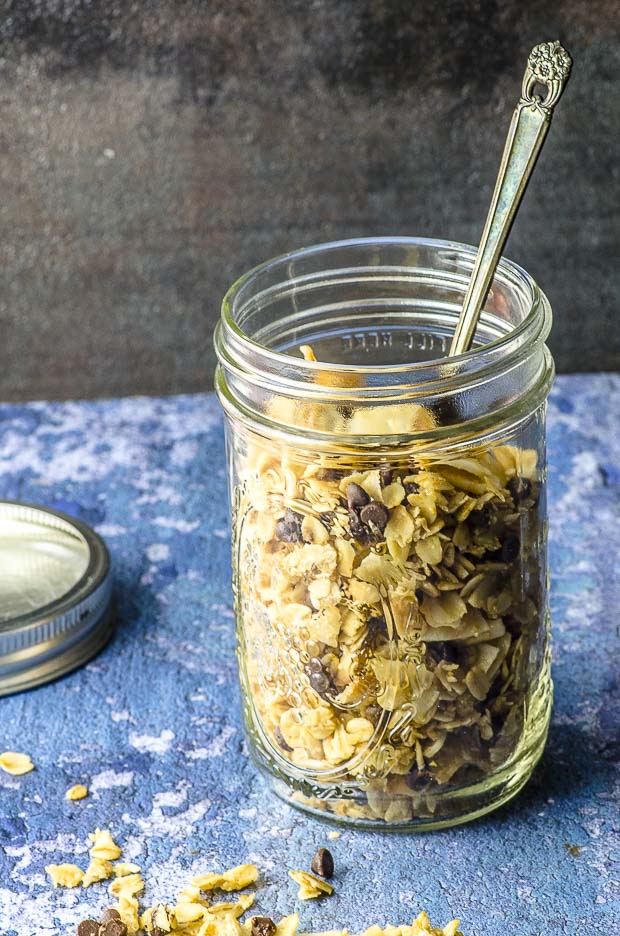 a glass jar filled with nut-free granola with chocolate and coconut