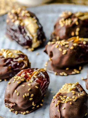 close up of a plate of Halva Stuffed Dates Dipped in Chocolate