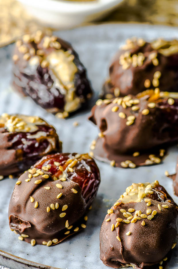 Recipes with dates:: close up of a plate of Halva Stuffed Dates Dipped in Chocolate