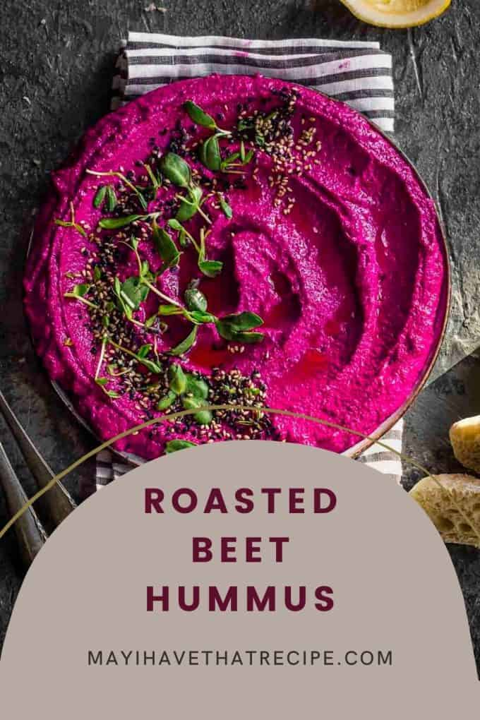 An overhead view of roasted beet hummus garnished on a striped towel