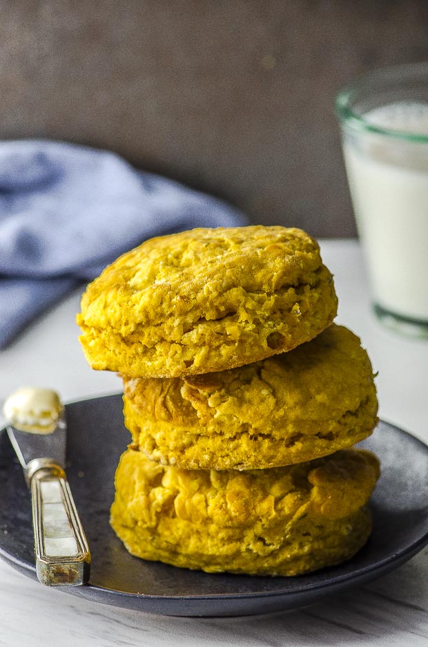 Three sweet potato vegan biscuits stacked on a black plate
