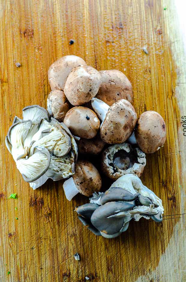 assorted mushrooms on a wood cutting board