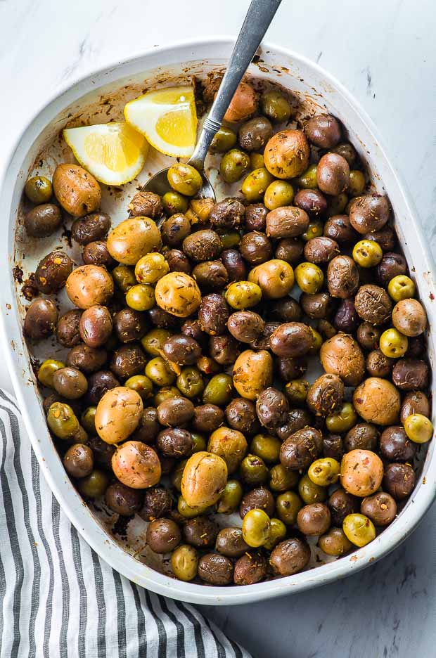 a white baking dish with roasted olives