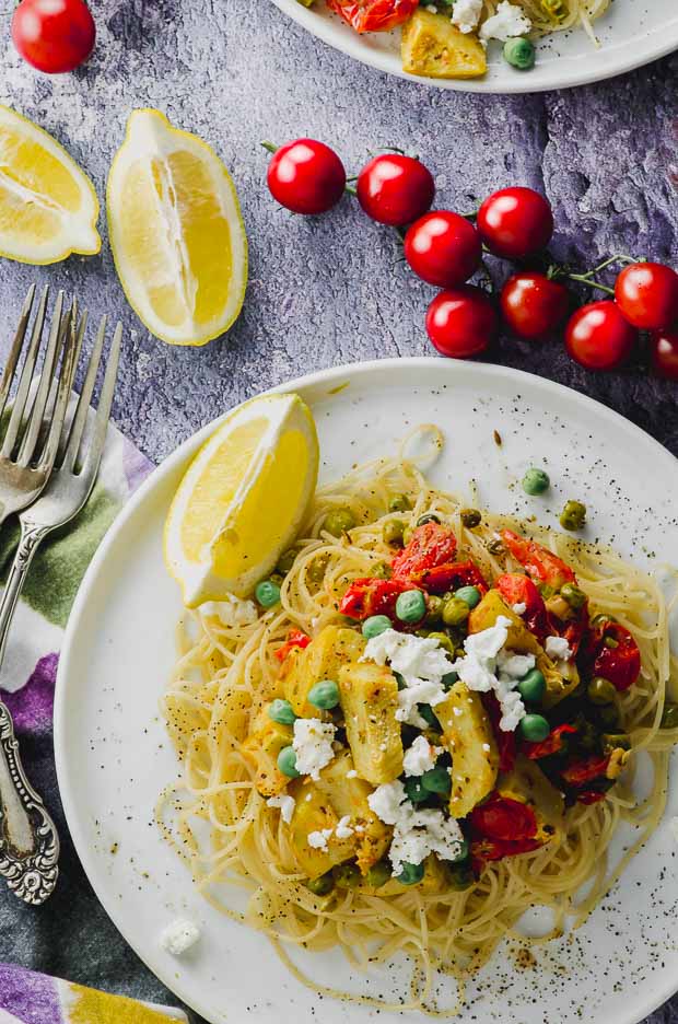 bird's eye view of a white plate with lemony pea and artichoke pasta