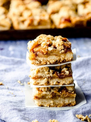 Side view of Apple oat bars piled on a piece of parchment paper