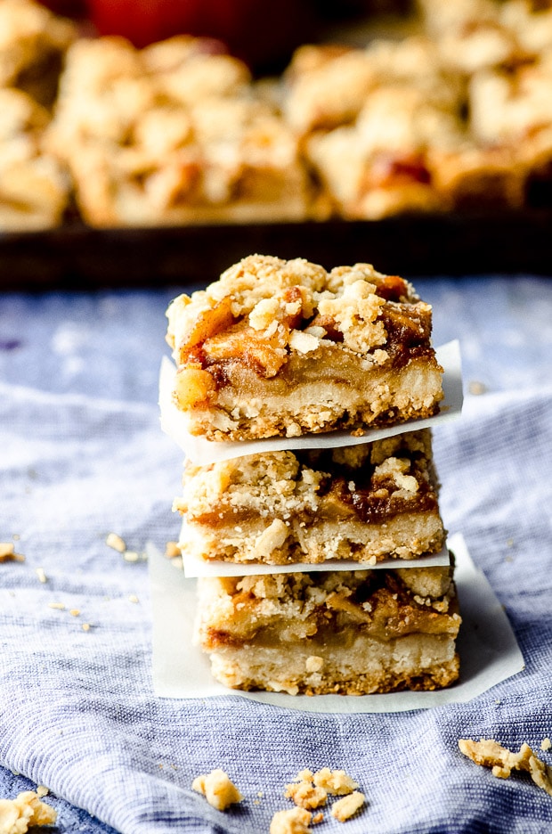Side view of Apple oat bars piled on a piece of parchment paper