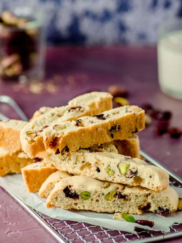 A pile of cranberry pistachio biscotti on a wire cooling rack