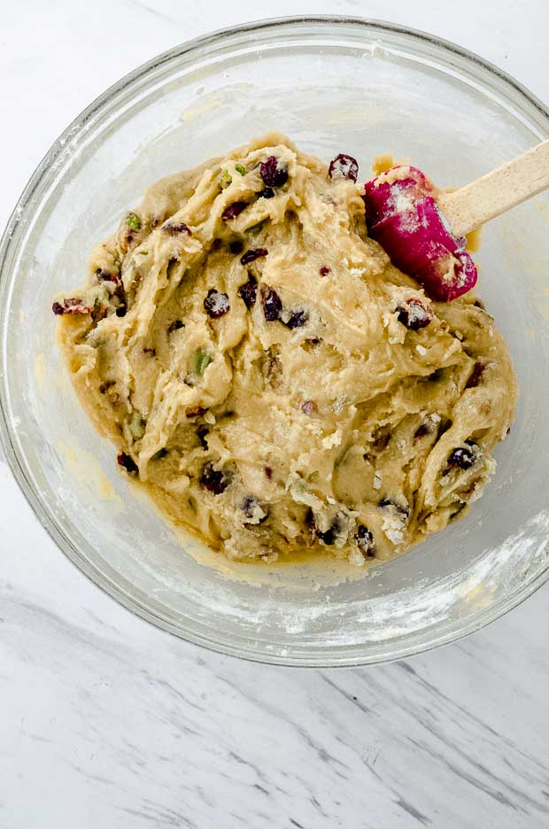 A clear bowl with cranberry pistachio cookie dough