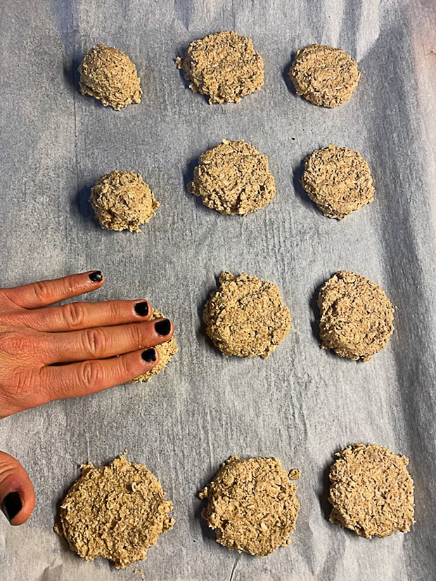 Pressing peanut butter oatmeal cookie dough into flat cookies
