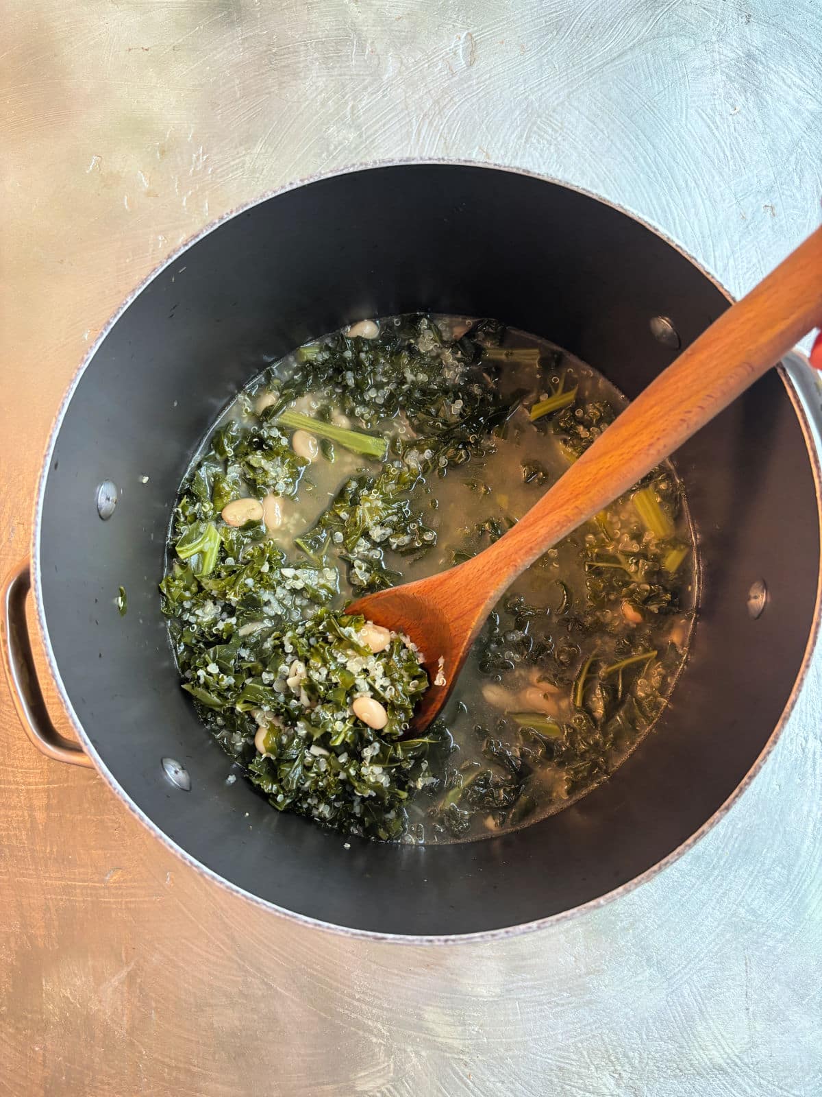 Quinoa soup with kale in a soup pot