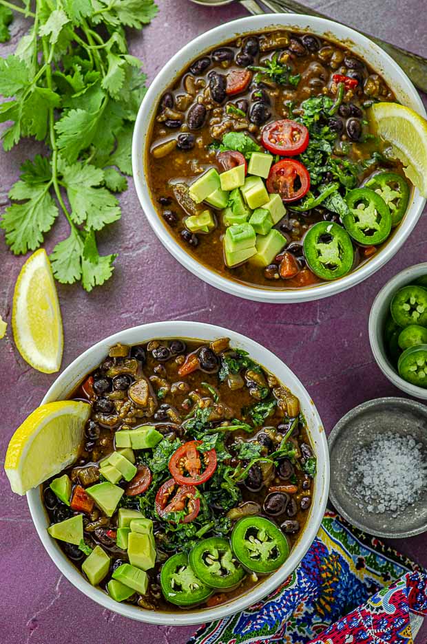 Bird's eye view of two white bowls filled with black bean soup'