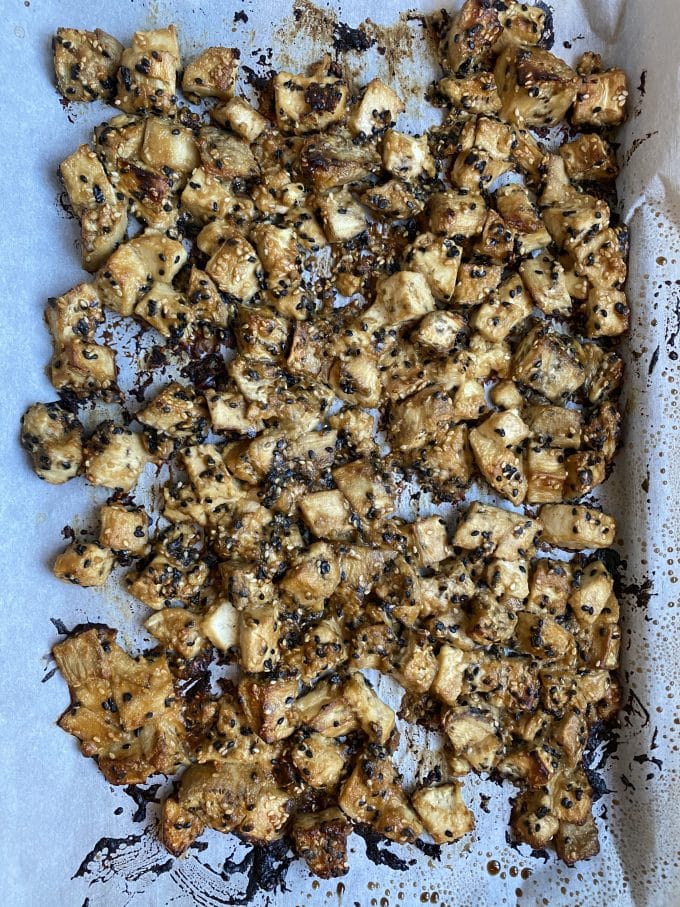 A baking sheet with baked eggplant and tofu with tahini-miso