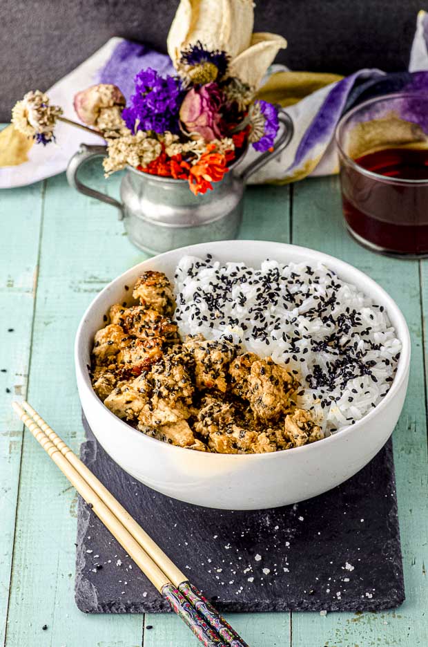 Side view of a white bowl with tahini-miso eggplant rice bowl