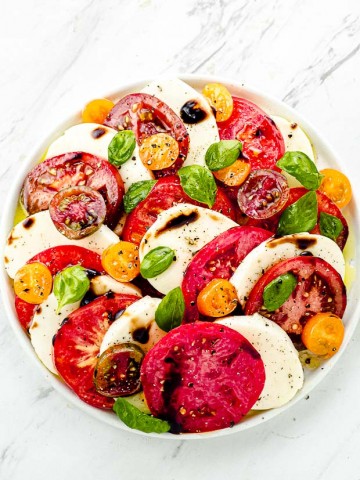 Bird's eye view of a Caprese salad with tomatoes, mozzarella and basil