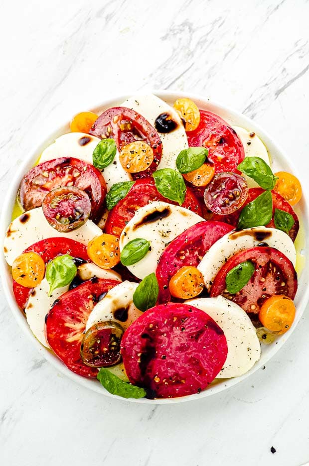 Bird's eye view of a Caprese salad with tomatoes, mozzarella and basil