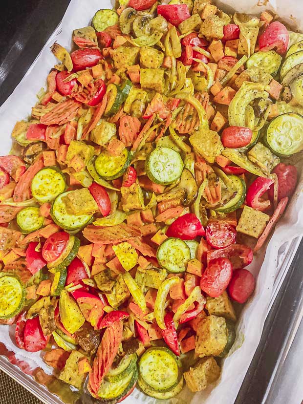 Spreading veggies with sauce on a baking sheet