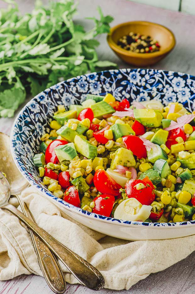 Side view of a bowl of corn salad with avocado