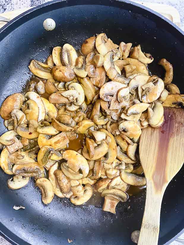 sliced mushroom with shawarma spice in a nonstick skillet