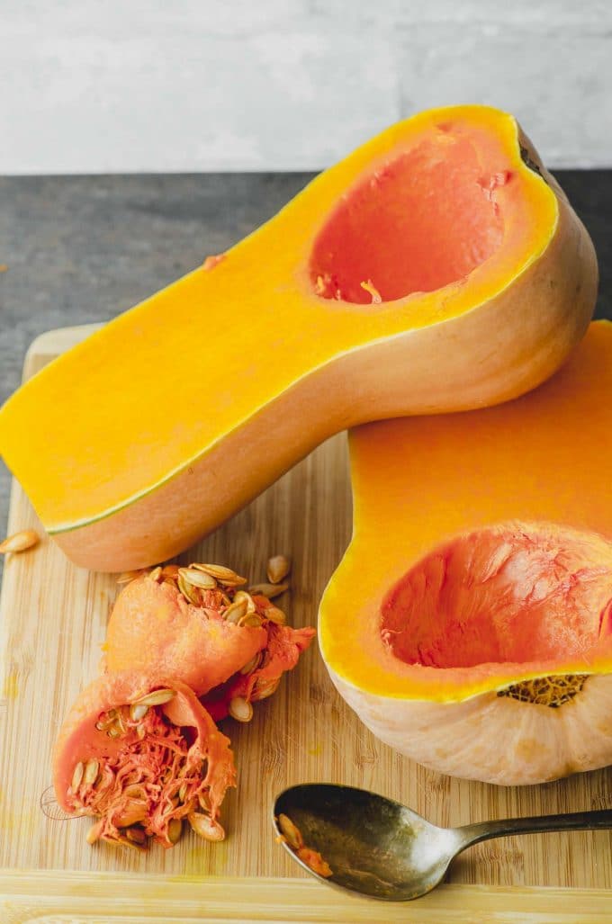 Two uncooked butternut squash halves with the seeds removed
