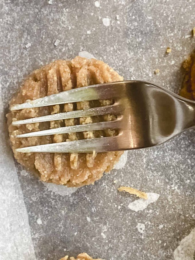 Making a crisscrossed pattern on a peanut butter cookie with a fork