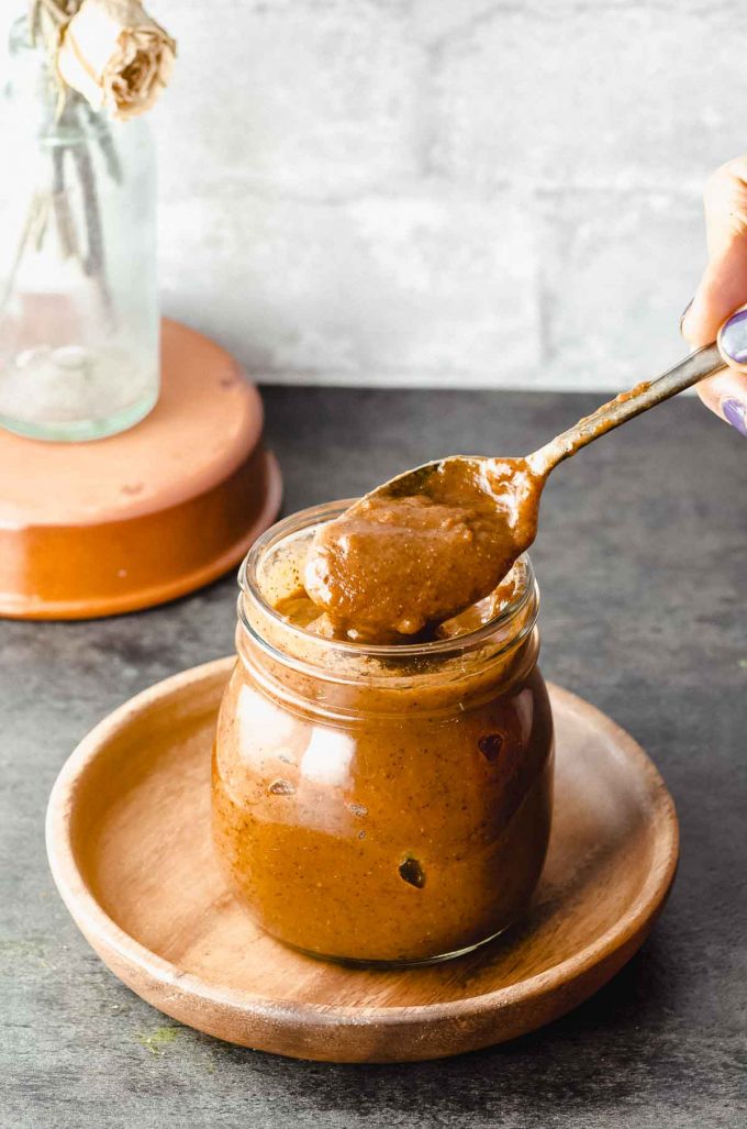 Taking a spoonful off a jar of homemade enchilada sauce