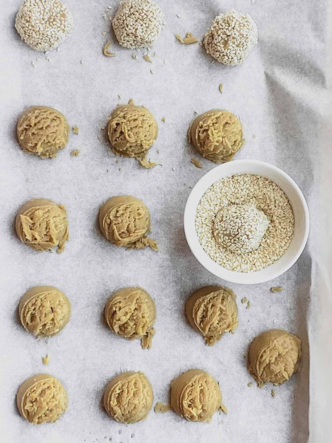 Tahini cookie dough in balls on a baking sheet